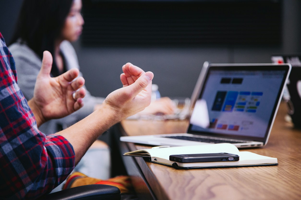 Mains en langue des signes devant un ordinateur